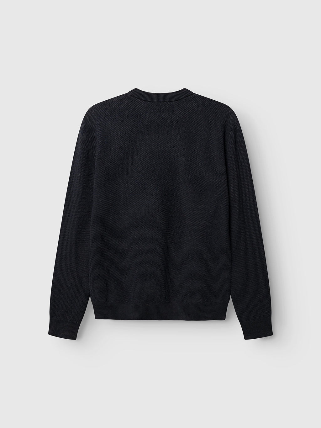 The GABlamix Coro O-Neck LS Knit by Gabba is shown in blue black against a light gray background, displayed from the back with no visible patterns or designs. Crafted from a soft cotton-blend knit, this regular fit long-sleeve sweater offers timeless comfort and versatile style.