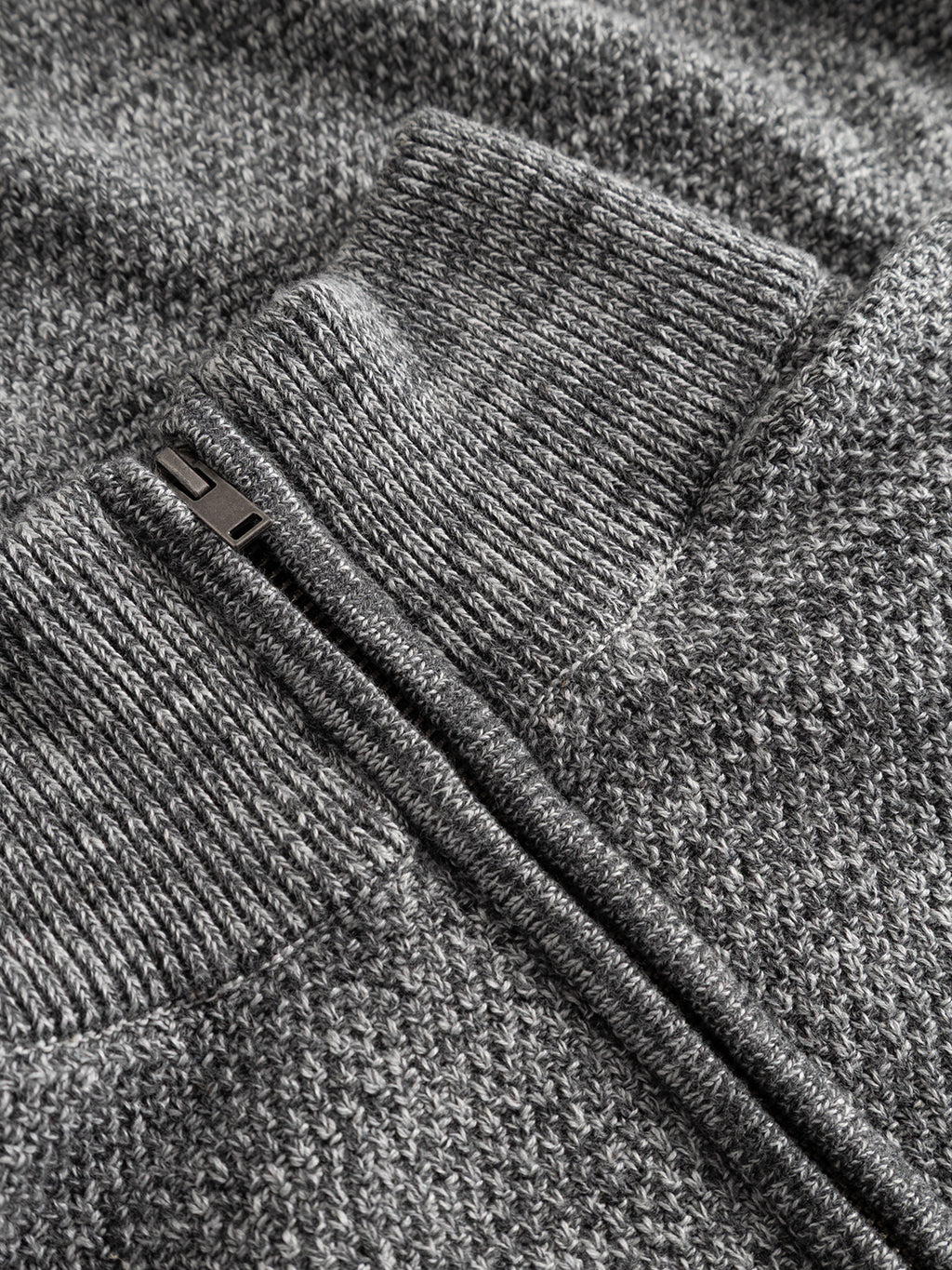 Close-up of the GABlamix Coro Half LS Knit in light grey from Gabba, a cotton-blend knit jacket featuring a zipper and ribbed cuffs. The detailed texture of the material is clearly visible, emphasizing its regular fit design.