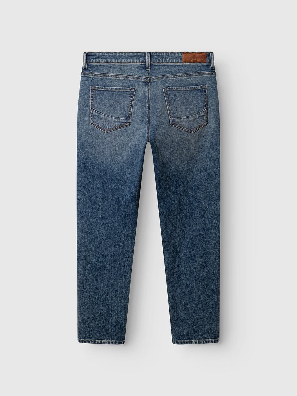 The Gabba GABmarc Silvi DS0007 Jeans in Mid Blue Denim are shown from the back, featuring two back pockets and a brown leather patch on the waistband. Crafted from comfort stretch denim in a regular fit, these jeans are laid flat on a light background.