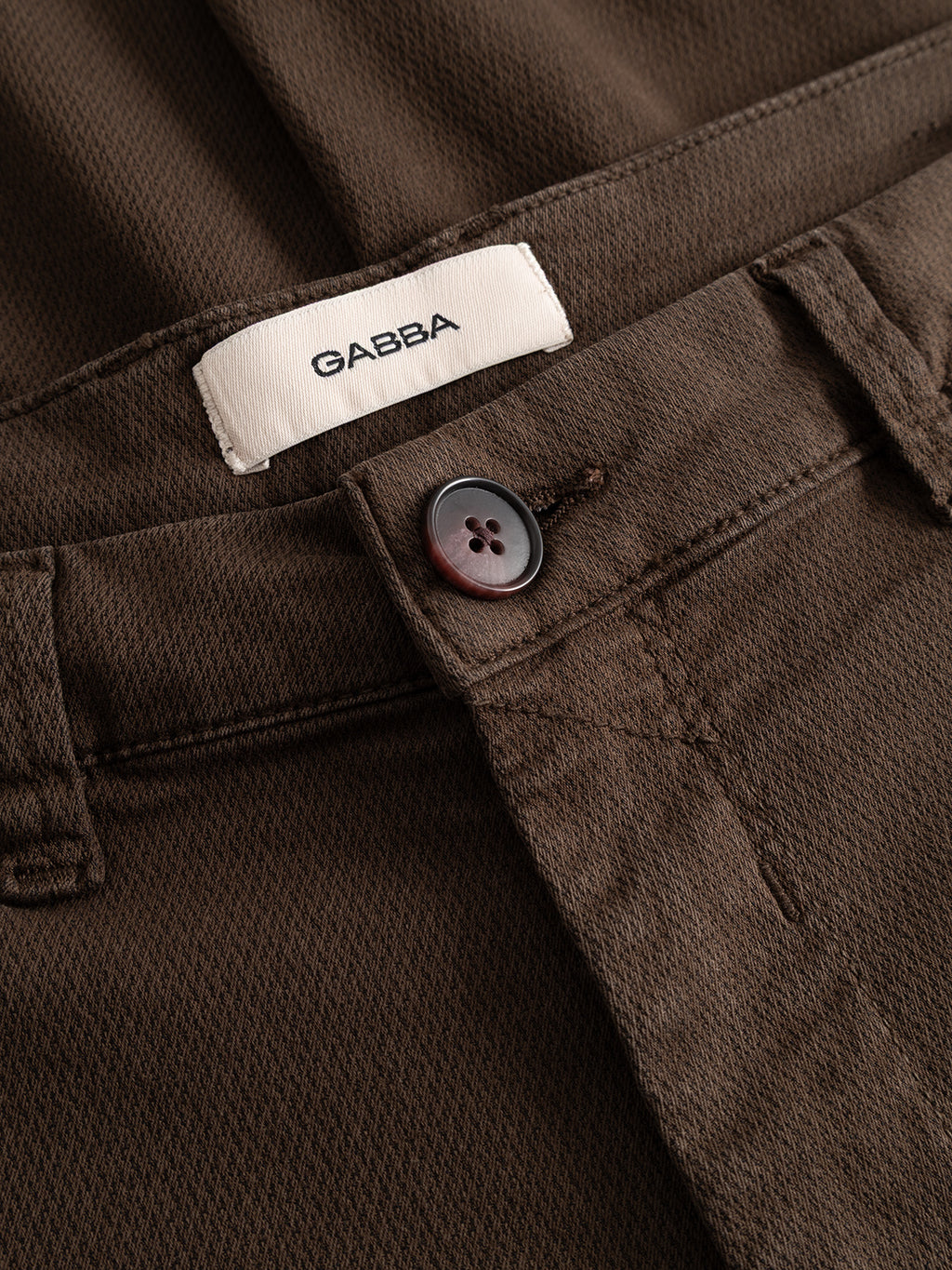 Close-up of the GABpaul K3280 Dale Chino in Brown Slate by Gabba, featuring a slim fit with a button closure and a white waistband label reading “GABBA,” made from high-stretch cotton-blend fabric for effortless comfort—ideal for everyday wear.