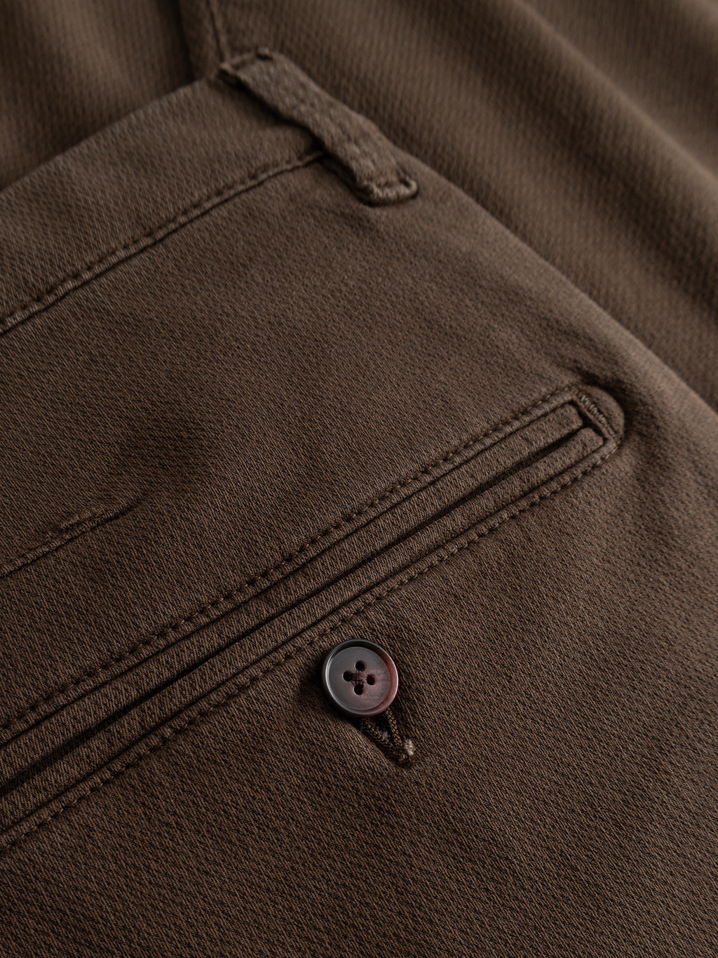 Close-up of the GABpaul K3280 Dale Chino in Brown Slate by Gabba, featuring a back pocket with a button and an above belt loop. The high-stretch cotton-blend fabric accentuates the texture and detailed stitching, making these Gabba chinos perfect for everyday wear.