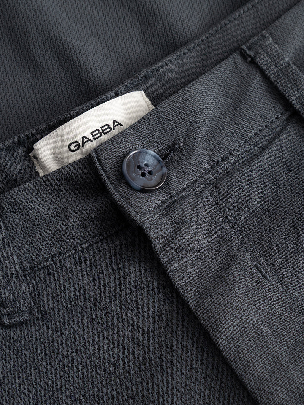 Close-up of Gabba GABpaul K3280 Dale Chino in Turbulence Blue, featuring a blue button, French pockets, waistband, and visible inner label with the Gabba brand name.