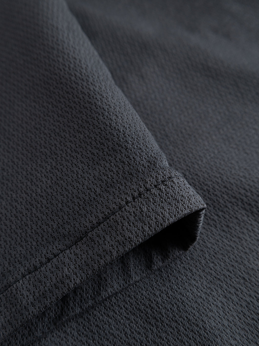 Close-up of a folded corner of Gabba’s GABpaul K3280 Dale Chino in Turbulence Blue, showing fine mesh-like textured fabric and visible hem stitching like that found on slim chinos with double-paspel back pockets.