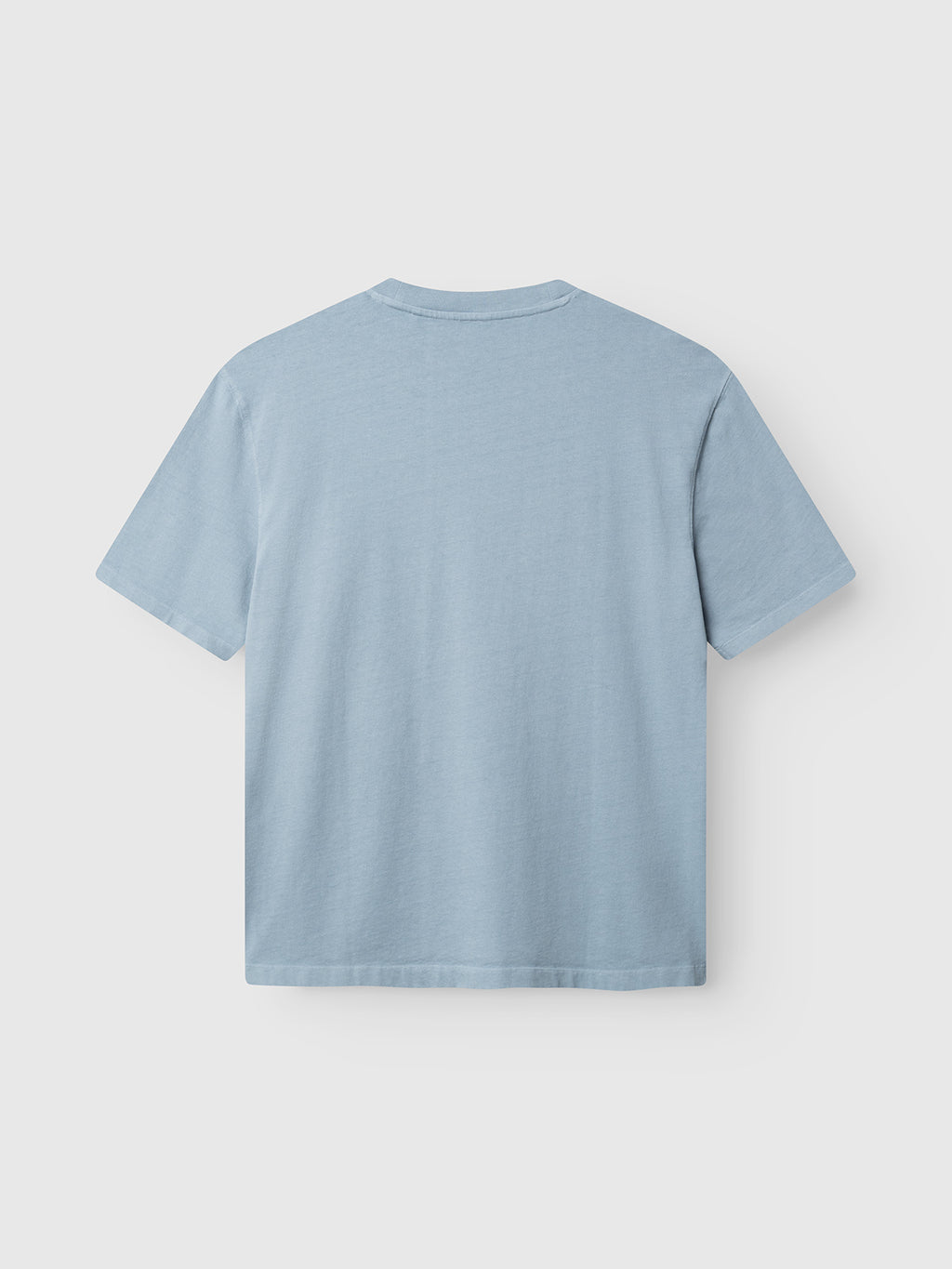 The Gabba GABlegin Wix Boxy Hour SS T-shirt in Dusty Blue is displayed from the back against a white background. Made from garment-washed cotton, this short-sleeve shirt offers a minimalist look without any visible graphics, logos, or patterns. Its relaxed boxy fit provides effortless style and comfort.