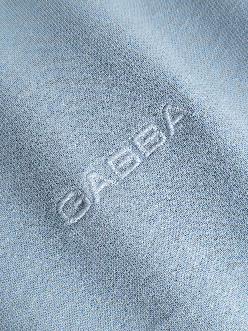 Close-up of the GABlegin Wix Boxy Hour SS T-shirt in Dusty Blue by Gabba, showcasing garment-washed light blue cotton fabric with the embroidered Gabba logo in matching thread for a subtle, textured look.