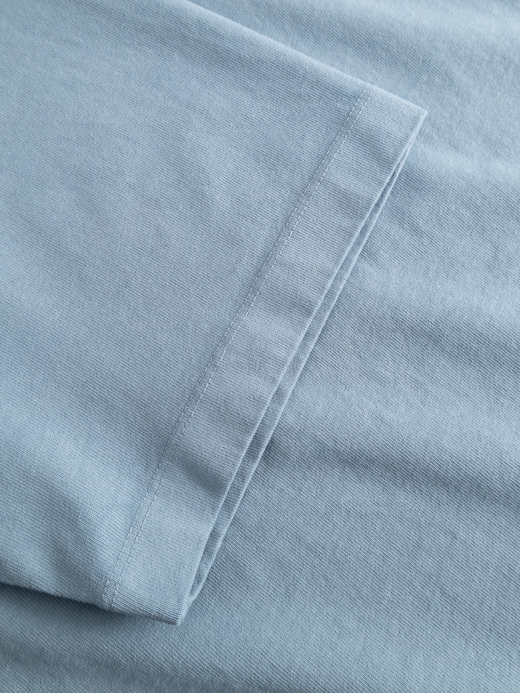 A close-up of the Gabba GABlegin Wix Boxy Hour SS T-shirt in Dusty Blue highlights its soft, garment-washed cotton fabric and the detailed sleeve seam. The embroidered Gabba logo adds a subtle accent to its relaxed, boxy fit.