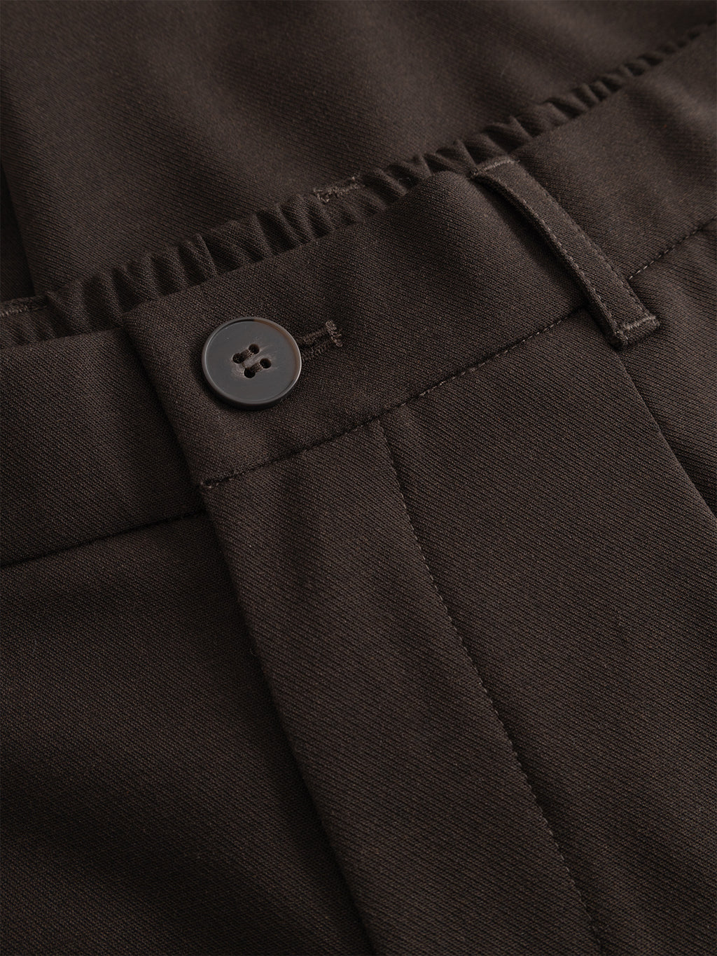 Close-up of the waistband and button on the Gabba GABnapoli 19 Phin GRS - Brown Slate wool blend chinos, highlighting stitching details, a belt loop, and an elastic section at the back.