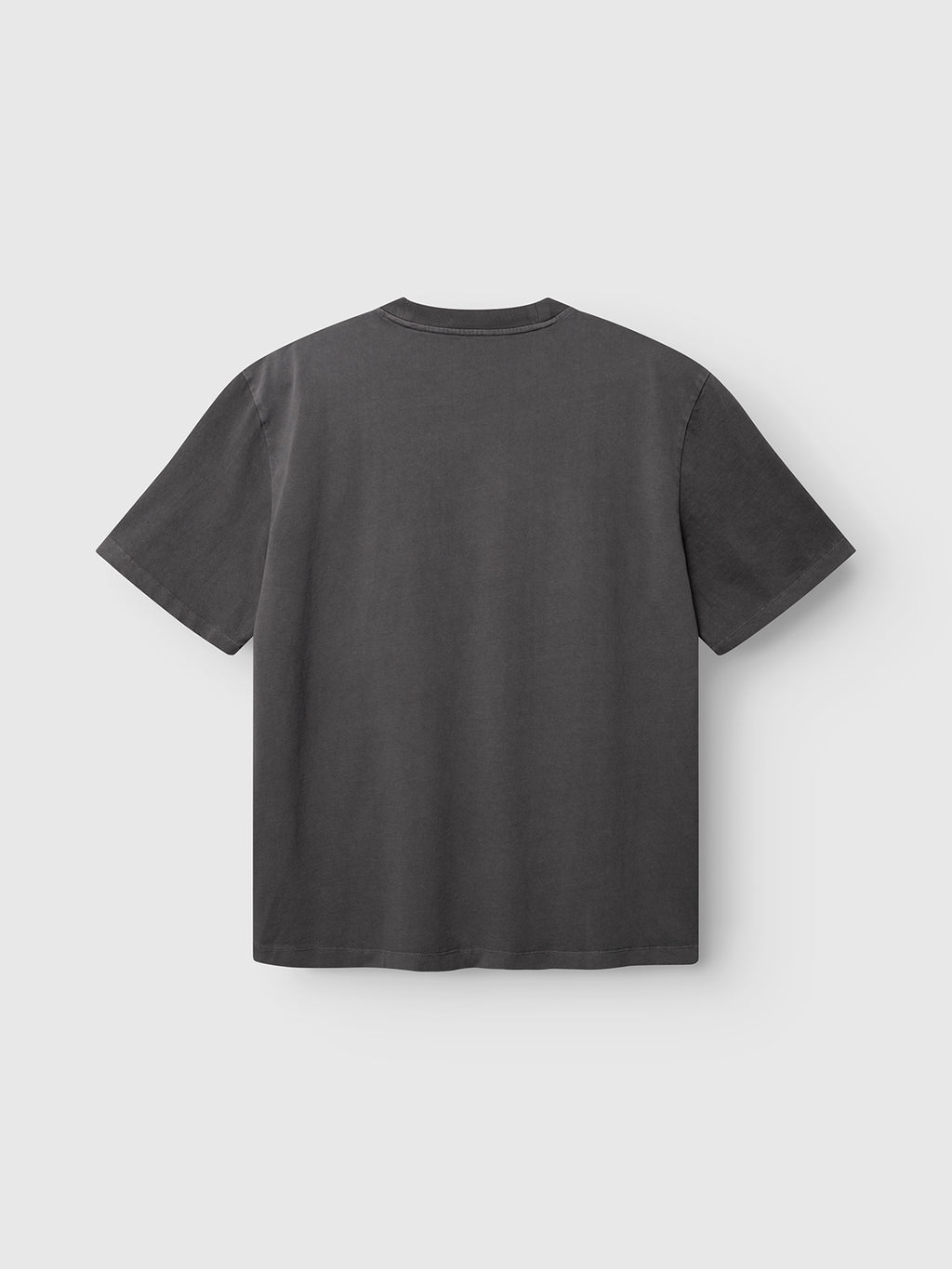 The Gabba GABnigel Wix Pkt Boxy Hour SS T-Shirt in dark grey is displayed laid flat with the back side facing up, set against a light gray background.