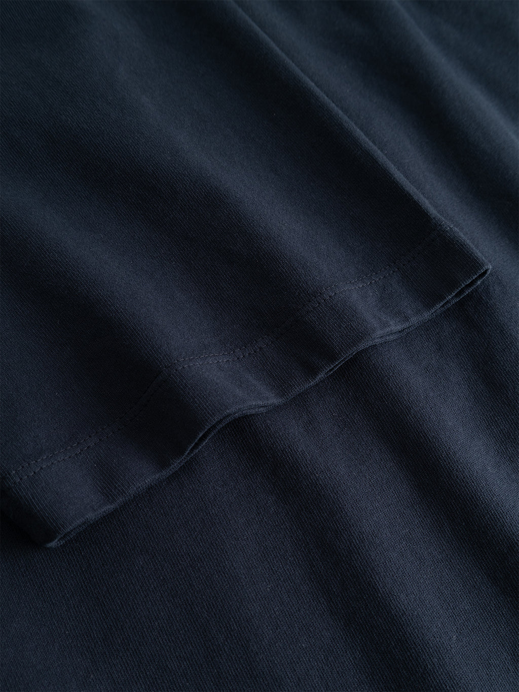 Close-up of the hem of the Gabba GABlegin Wix Boxy Hour Lobby2 SS T-shirt in Night Sky, crafted from textured cotton jersey, highlighting the smooth fabric texture and stitching details.
