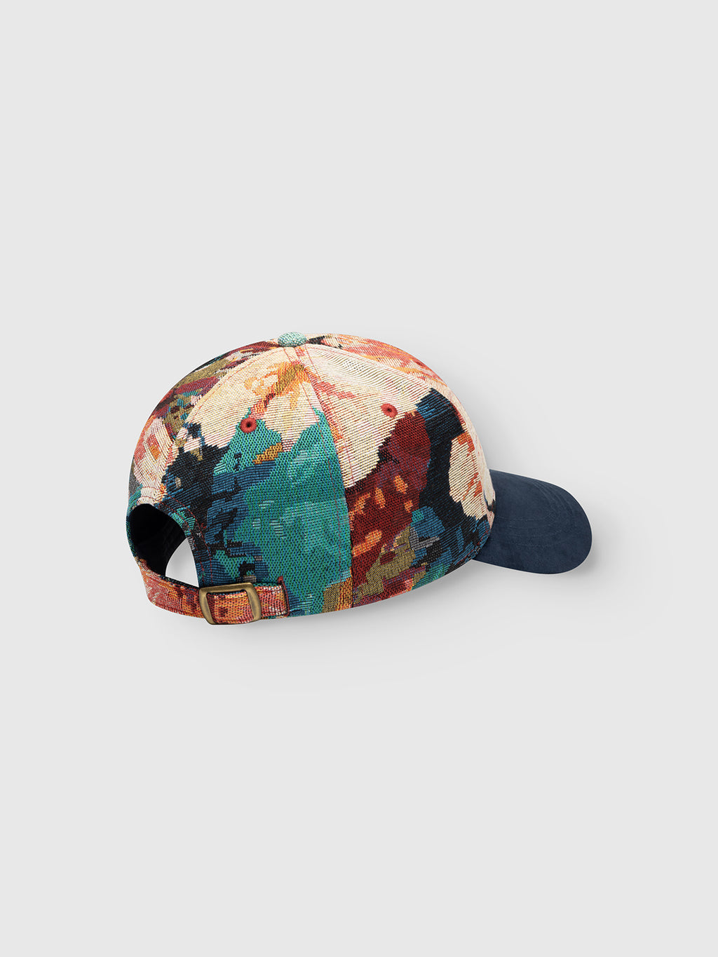 The GABrichi Fiore Cap - Multi Pattern by Gabba is a multicolored jacquard cap featuring an abstract pattern, a solid navy blue brim, and an adjustable back strap with a buckle. The embroidered Gabba logo adorns the front, and the cap is displayed on a light gray background.