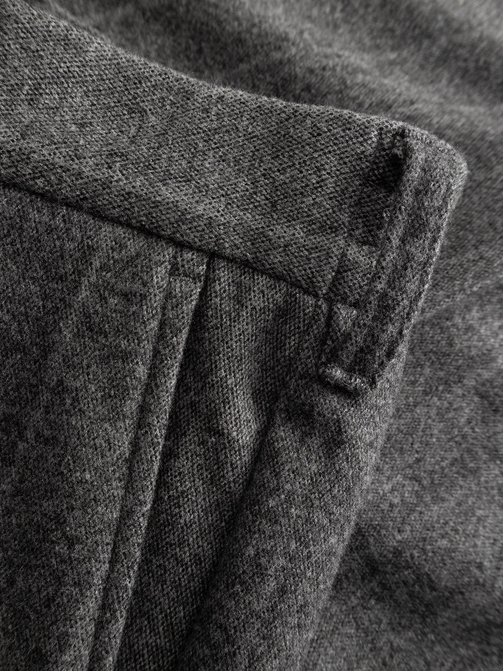Close-up of the Napoli 19 AX Stripes - Dark Grey wool fabric by Gabba, showcasing its soft texture and detailed edge stitching—making it an ideal choice for relaxed fit pants featuring chino pocket construction and an elasticated waistband.