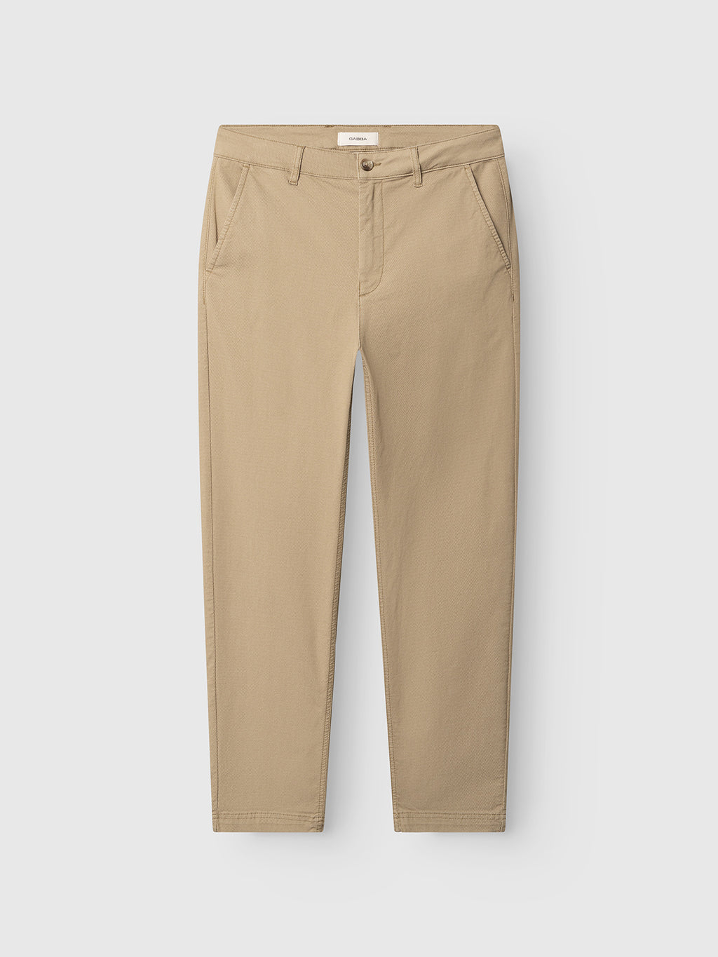 The Gabba GABjoe Nopleats Dale Pant in sand is a pair of beige tapered-fit chinos with side pockets and button closure, made from high-stretch cotton-blend fabric, shown laid flat on a white background.