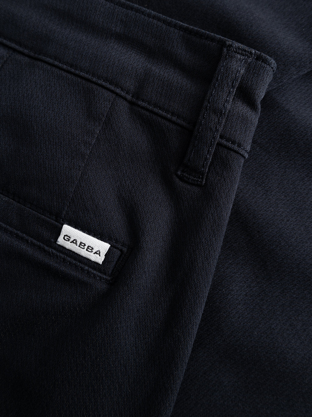 Close-up of a Gabba GABjoe Nopleats Dale Pant in Blue Black, highlighting the front pocket with a small white Gabba label, plus part of the waistband and belt loop.