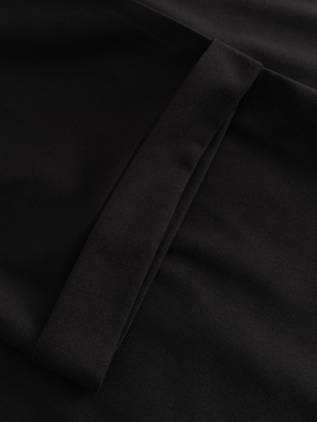 A close-up of the Gabba GABjoe Turnup Fin Pant in black shows its smooth twill viscose blend, neatly sewn pocket, and sharp fold—highlighting the precise tailoring of these classic chinos.