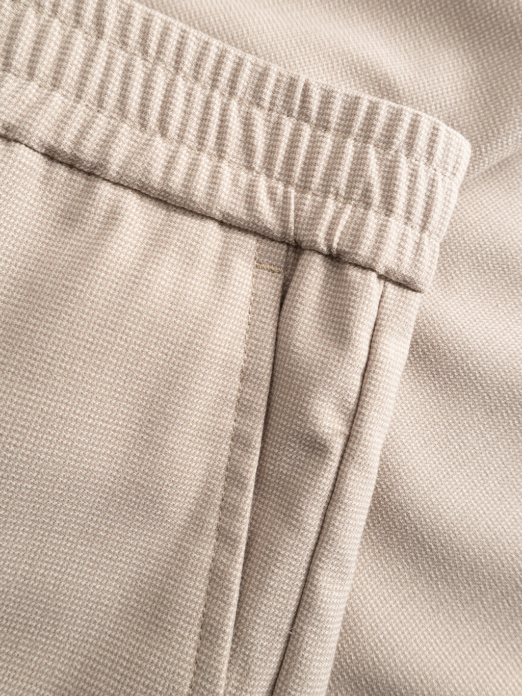 Close-up of Gabba GABmonza Tasca Deme Pant in Birch, showcasing its textured beige linen, elastic waistband, side pocket with visible stitching, and relaxed straight fit.