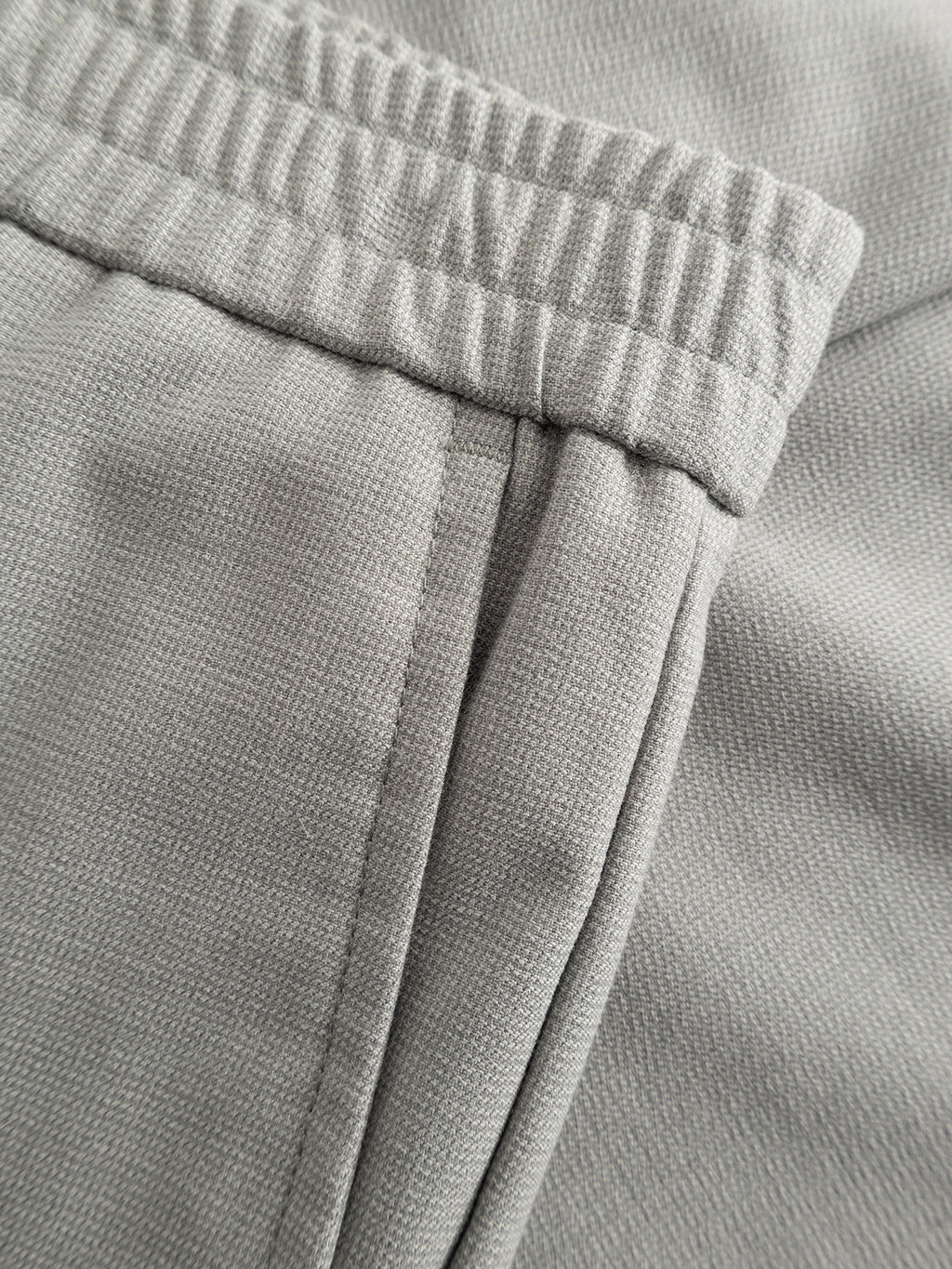 Close-up of the Gabba GABmonza Tasca Deme Pant in Mineral Gray, showing textured fabric, an elastic waistband, and a partial pocket—ideal for relaxed summer style.