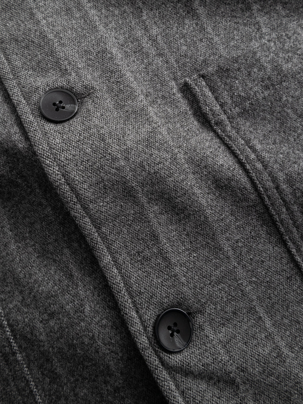 Close-up of the Gabba GABlibre AX Stripes LS Overshirt in dark grey, highlighting its boxy fit, two black buttons, and a narrow vertical pocket. The image shows the wool-viscose blend fabric’s texture and subtle pinstripe detailing.