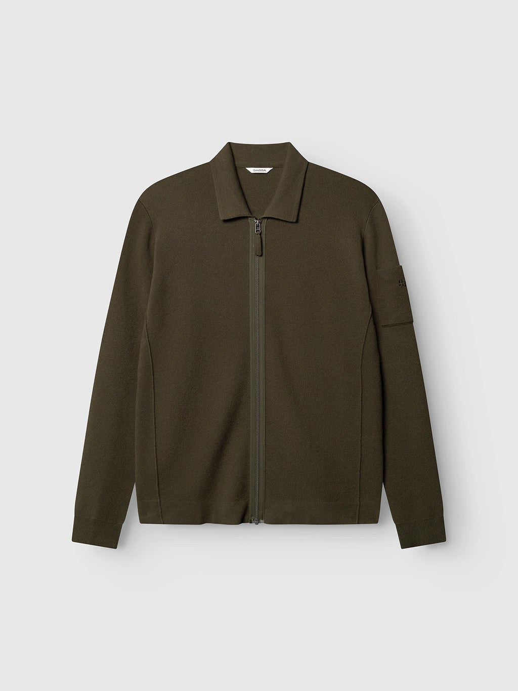 Gabba’s GABadriel Zip Lume LS Knit in Forest Night is a regular-fit zip-up jacket featuring a collar, long sleeves, and a subtle pocket detail on the left sleeve. Crafted from a soft viscose blend with a full zip closure, it is displayed against a plain light gray background.
