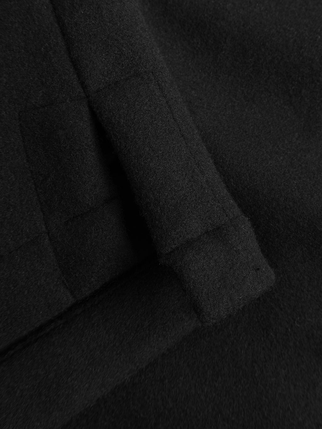 Close-up of the Gabba GABtheo City Jacket in black, featuring a wool-inspired fabric with a folded edge and soft, textured surface—ideal for everyday layering or as an overshirt jacket.