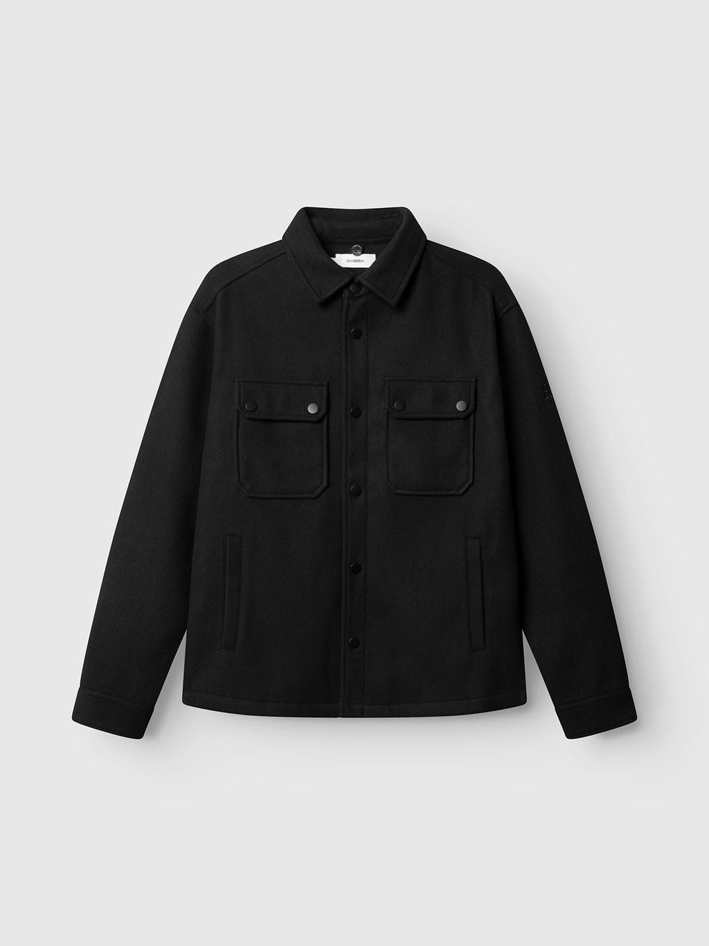 The Gabba GABtheo City Jacket in black features a classic collar, long sleeves, and two front chest pockets, crafted from wool-inspired fabric for effortless everyday layering. Shown against a plain light gray background.