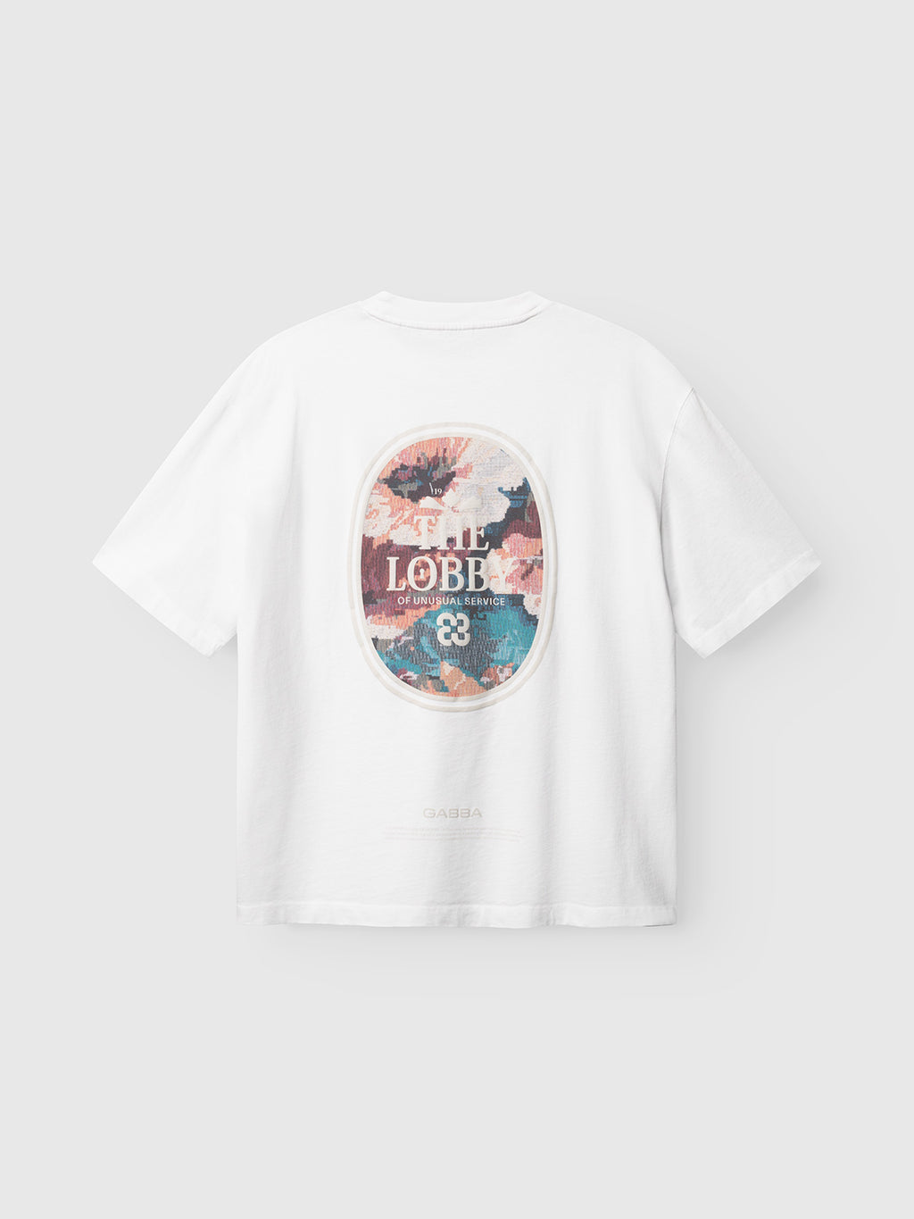 The GABlegin Boxy Fiore SS T-Shirt in white by Gabba is crafted from textured cotton jersey and showcases a vibrant oval graphic on the back with abstract shapes, the words “LOBBE” and “OF UNUSUAL BEAUTY,” and a small emblem featuring the number 22. Designed for a relaxed, boxy fit, this contemporary staple effortlessly blends comfort with modern style.