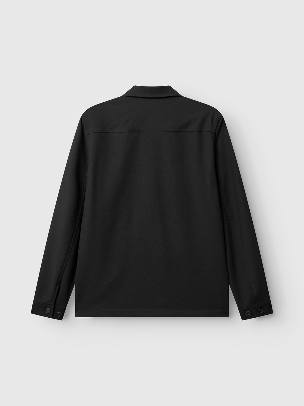 The GABtogger Push Phin LS Overshirt GRS by Gabba, shown in black, is displayed from the back against a light gray background. Crafted from a wool-viscose blend, this long-sleeve collared overshirt features buttoned cuffs and a clean, minimal design with no visible patterns or logos—making it an essential layering piece for any wardrobe.