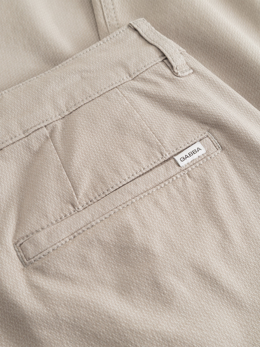Close-up of the GABjoe-pas Dale Pant - Grey Paloma by Gabba, highlighting a back pocket with a small white CAREBA label. The high-stretch cotton-blend fabric features a textured finish, and the pocket has a single horizontal opening.