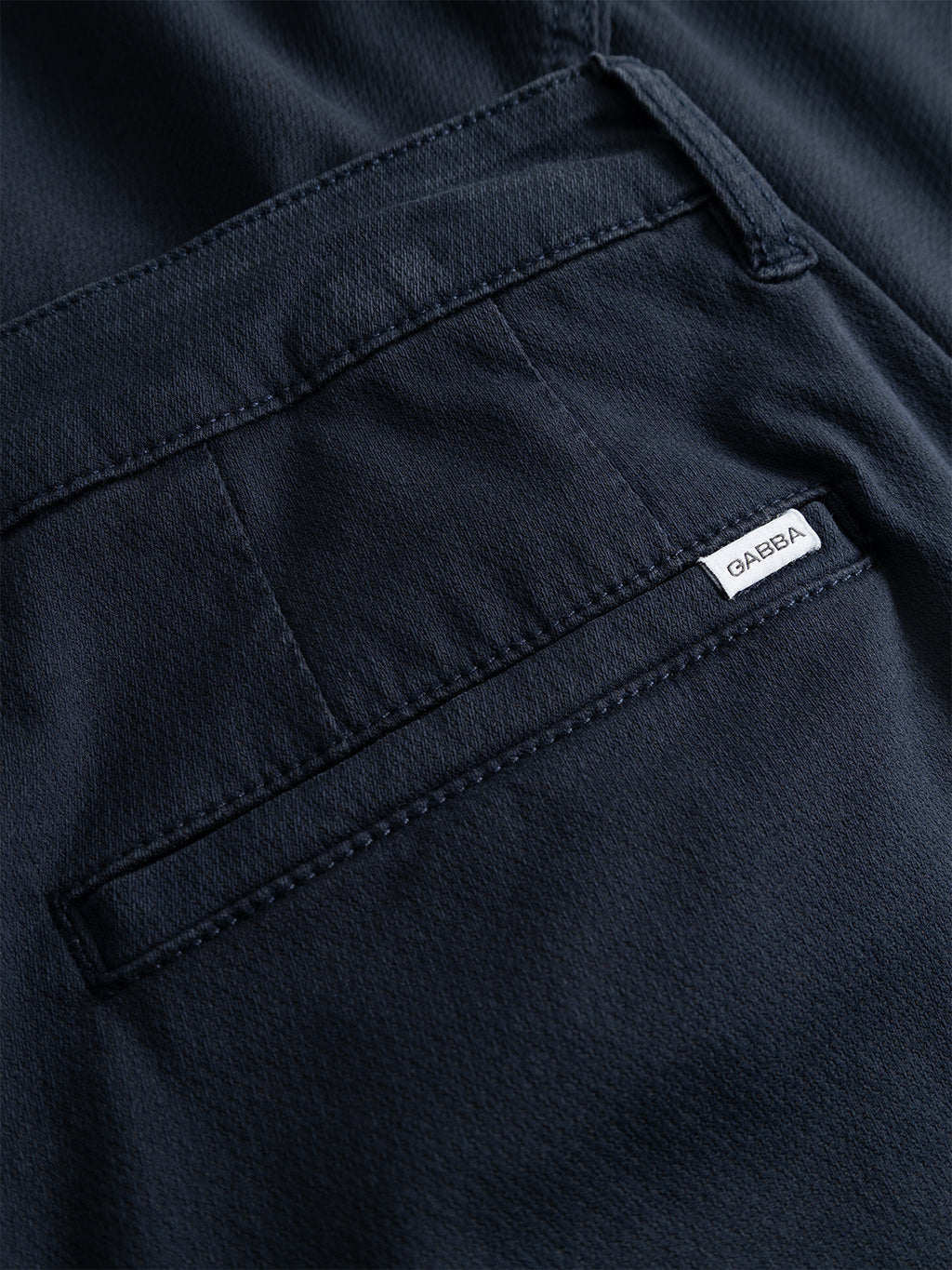 Close-up of a navy blue fabric pocket on the Gabba GABjoe-pas Dale Pant - Blue Black, featuring visible stitching and a small white tag reading “QABAQ” near the pocket opening, which accentuates the high-stretch cotton-blend material used in these tapered fit pants for a modern silhouette.