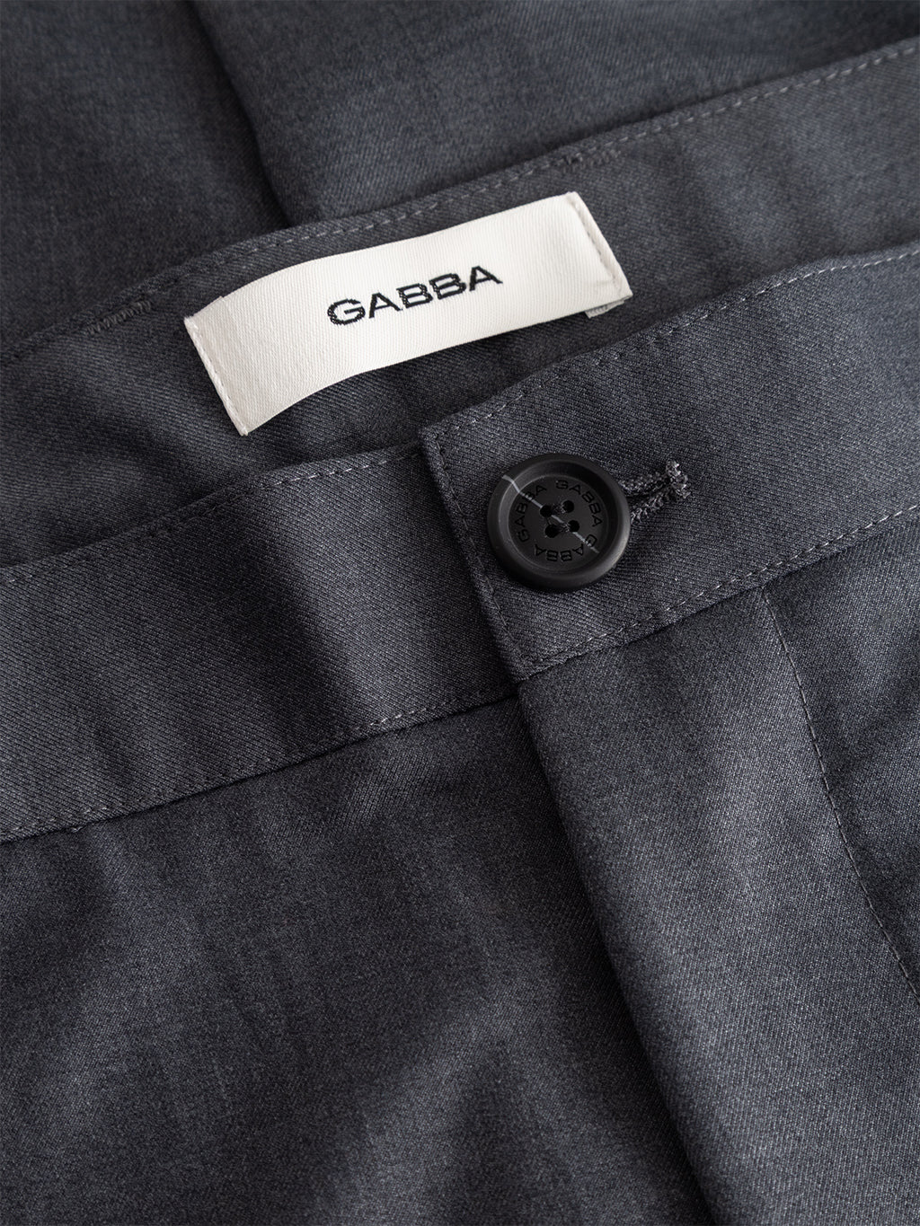 Close-up of the GABjoe Turnup Fin Pant in light grey by Gabba, featuring a tapered fit, black button, and a white Gabba label sewn inside the waistband.