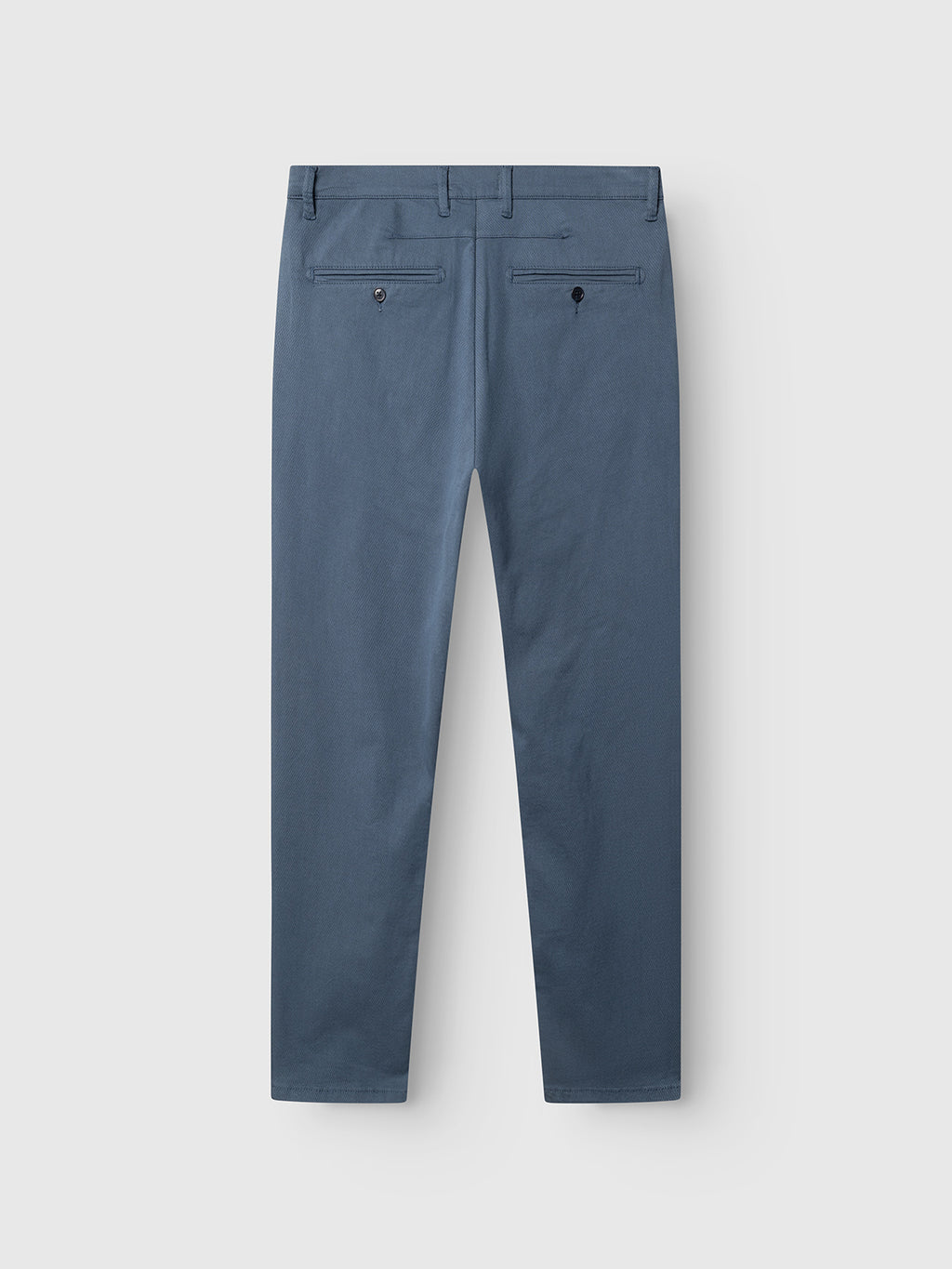 The GABpaul K3280 Dale Chino in Bering Sea by Gabba is shown laid flat from the back. These slim men's chinos feature side French pockets, two buttoned back pockets, and belt loops on the waistband.