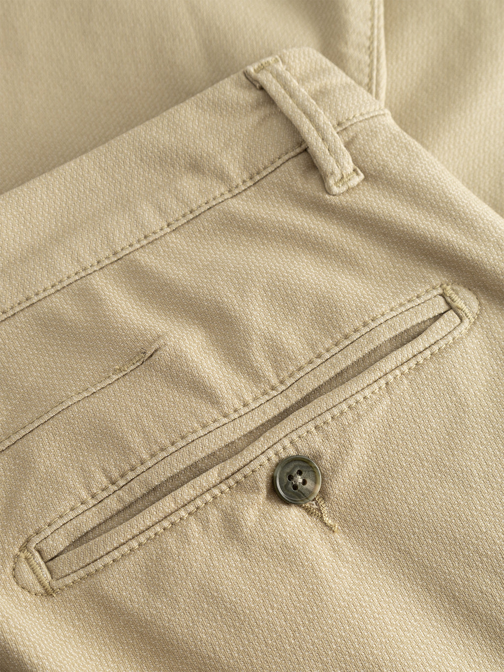 Close-up of the back pocket on the Gabba GABpaul K3280 Dale Chino in Alfa Green, showing a button closure, seam detail, classic belt loop above the pocket, and visible fabric texture.