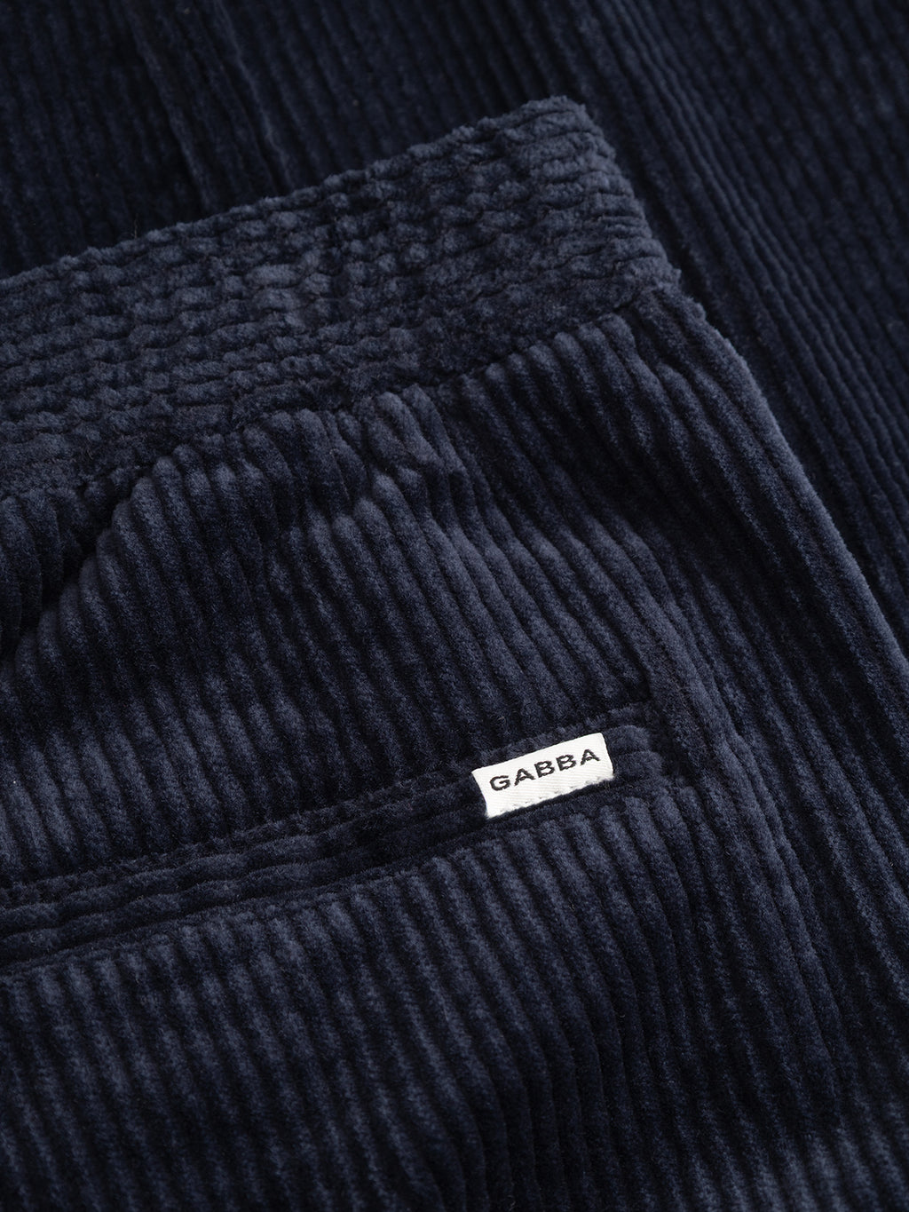 Close-up of the dark navy GABnapoli 19 Ibre Pant in cotton corduroy, featuring a small white Gabba brand label on a pocket.
