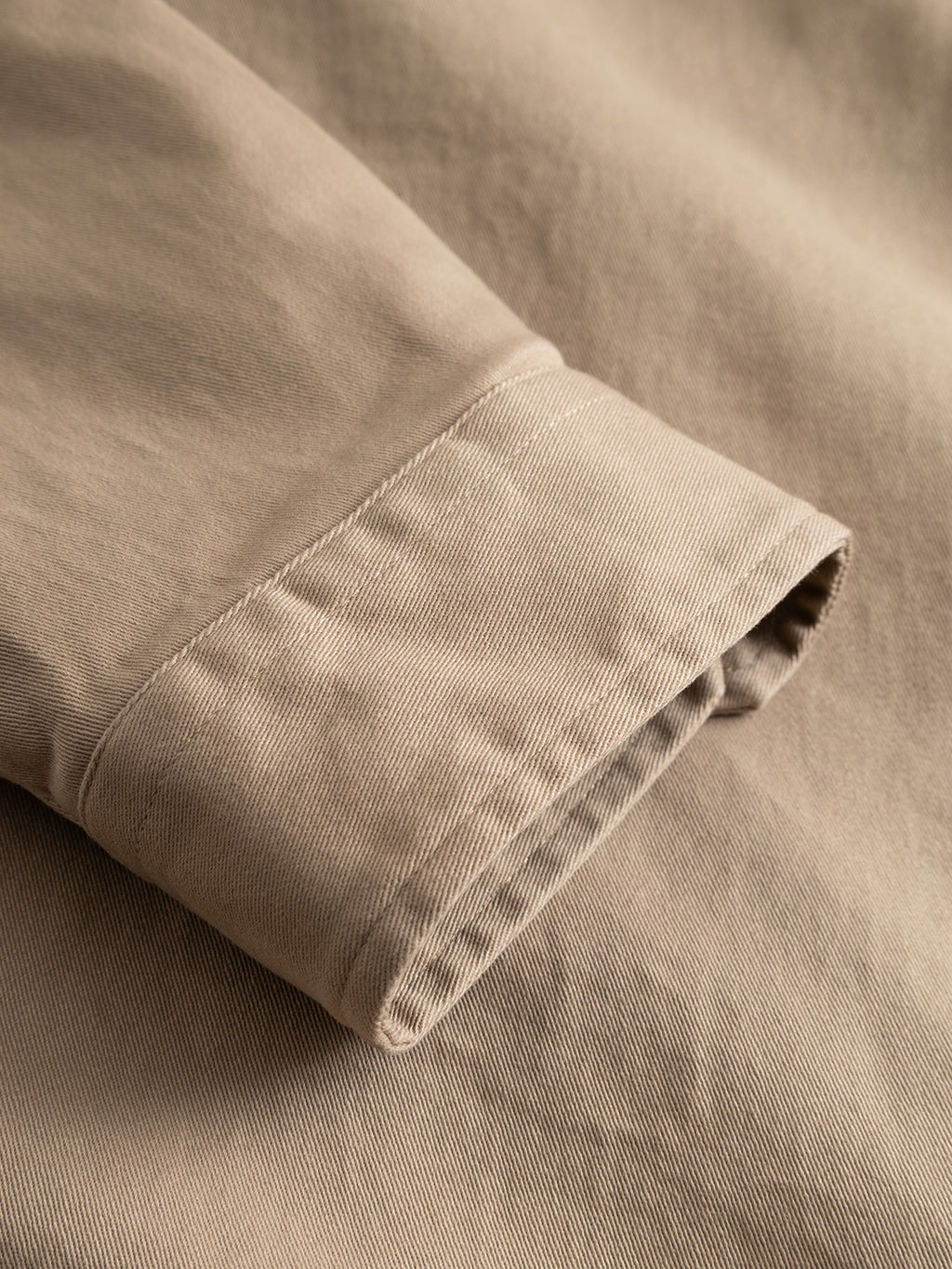 A close-up of the cuff of the Gabba GABtopper LS Shirt - Sand Plaza showcases its textured fabric, detailed stitching, and smoothly folded sleeve—an essential heavyweight overshirt with a regular fit, perfect for stylish layering.