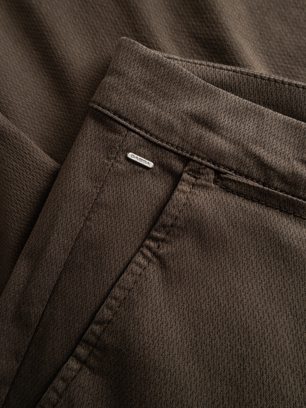 A close-up of the Gabba GABpaul K3280 Dale Chino in dark brown, showcasing the textured fabric, waistband, belt loop, French pockets, and a small metallic brand tag.