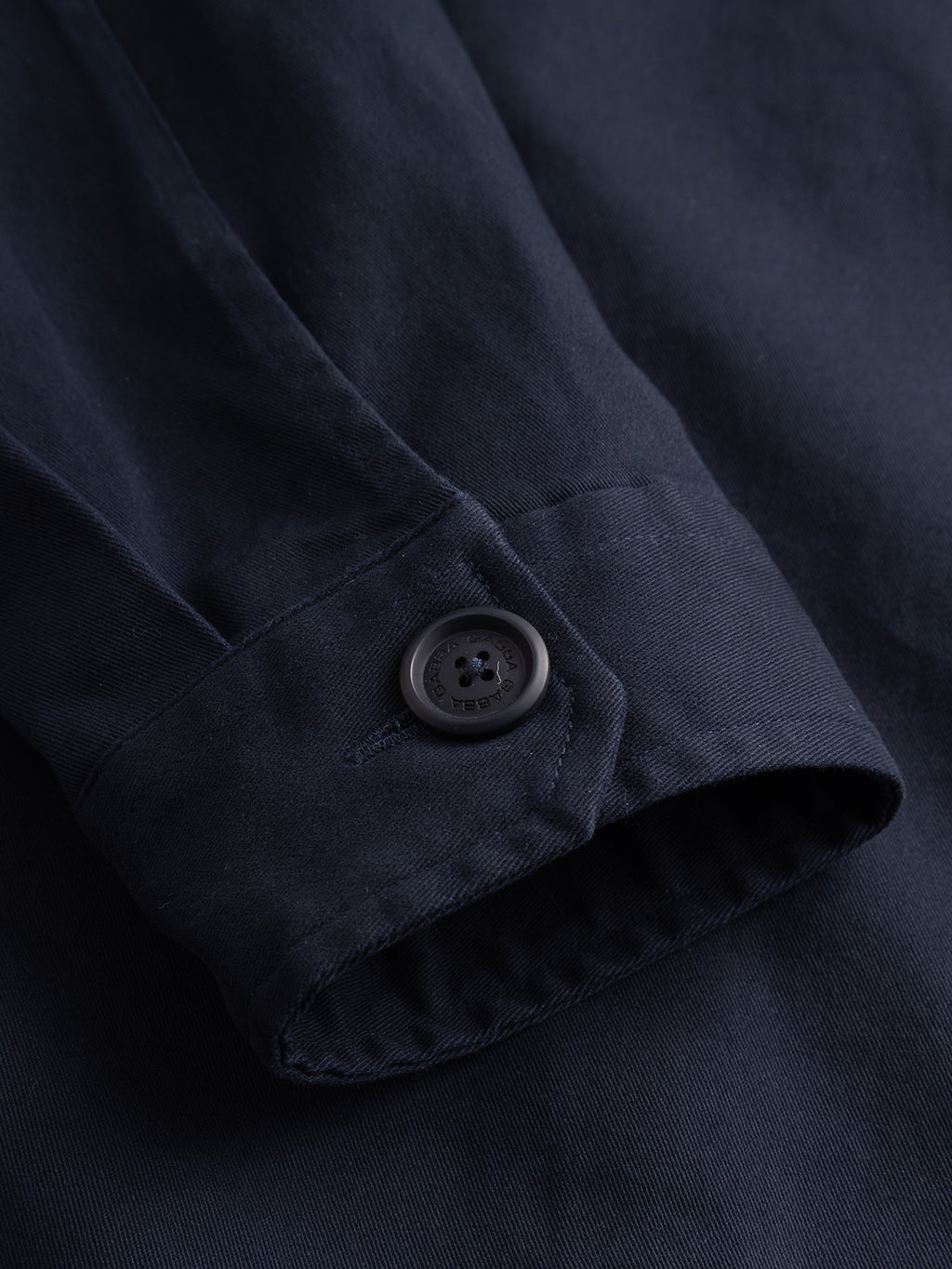 Close-up of the Gabba GABtopper LS Shirt in Blue Black, featuring a fastened black button at the cuff that highlights the shirt’s refined stitching and textured fabric—an essential layering piece designed to pair seamlessly with your favorite heavyweight overshirt.