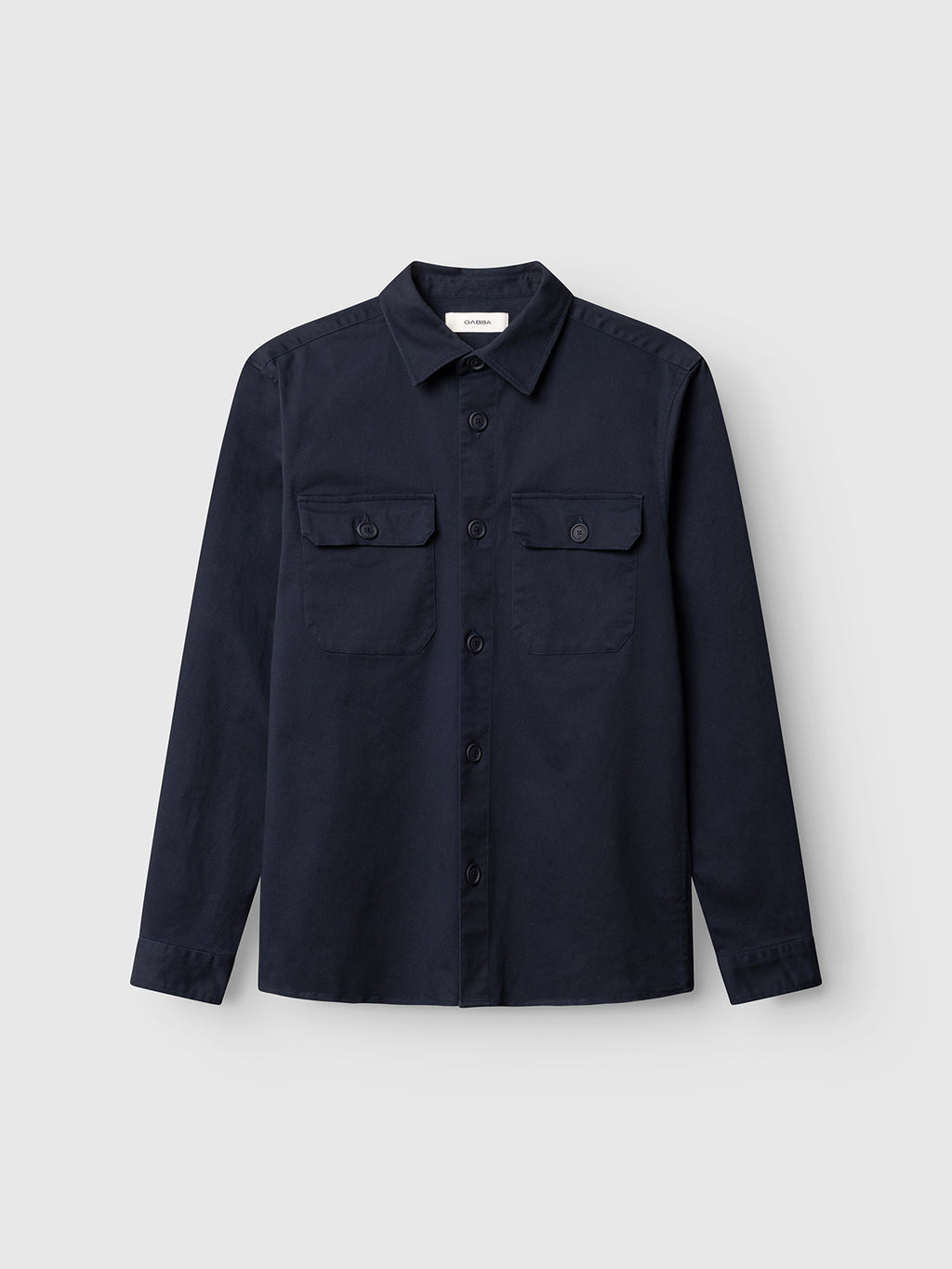 The Gabba GABtopper LS Shirt in Blue Black is a heavyweight, navy long-sleeve button-up with two chest pockets and a classic collar, laid flat on a light gray background—an essential overshirt for effortless style and comfort.