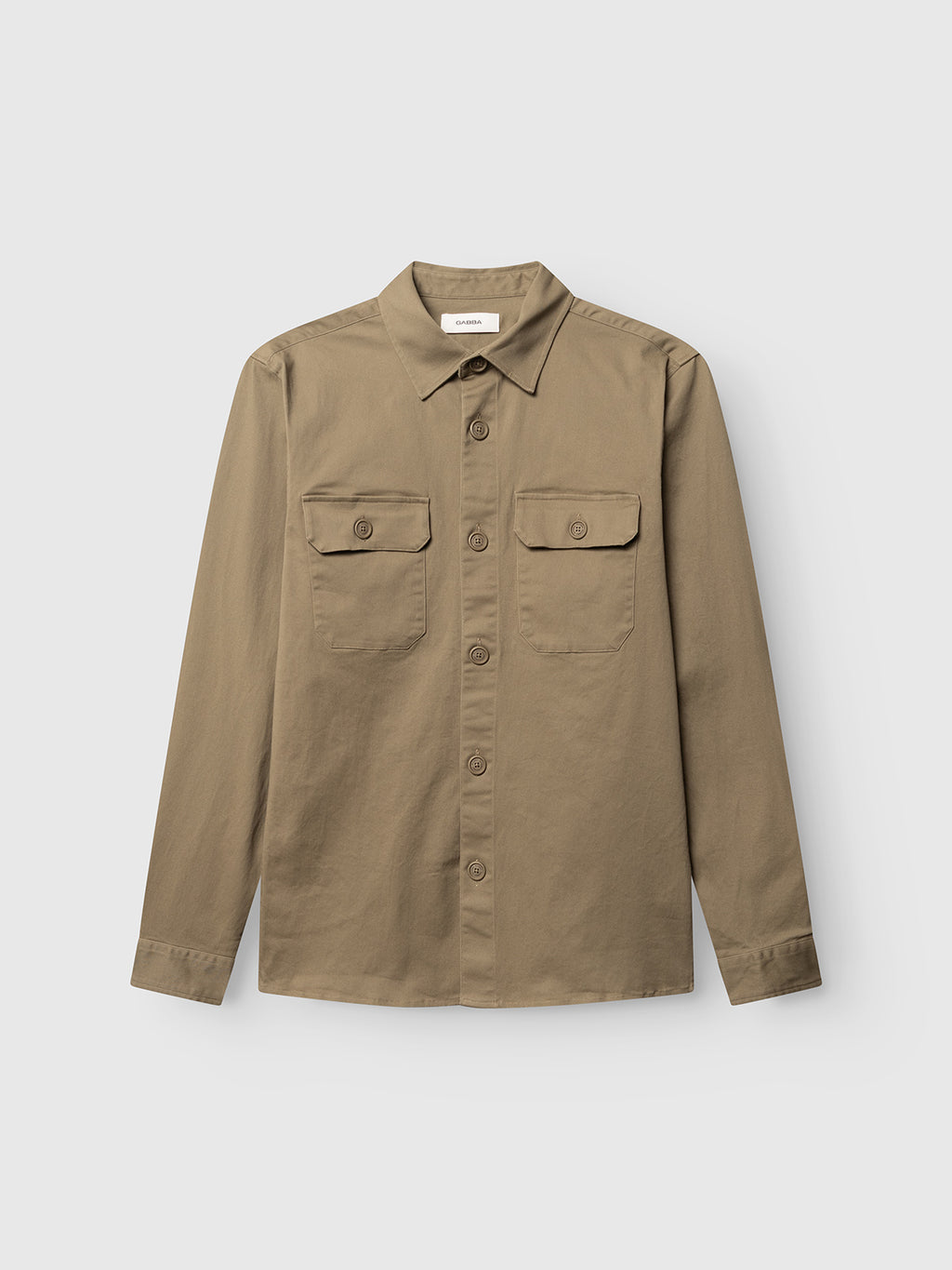 The Gabba GABtopper LS Shirt in Dusty Olive is a long-sleeve, button-up shirt with two front chest pockets—each secured with a flap and button closure—shown laid flat on a white background. With its regular fit, this versatile layering essential offers endless styling options.