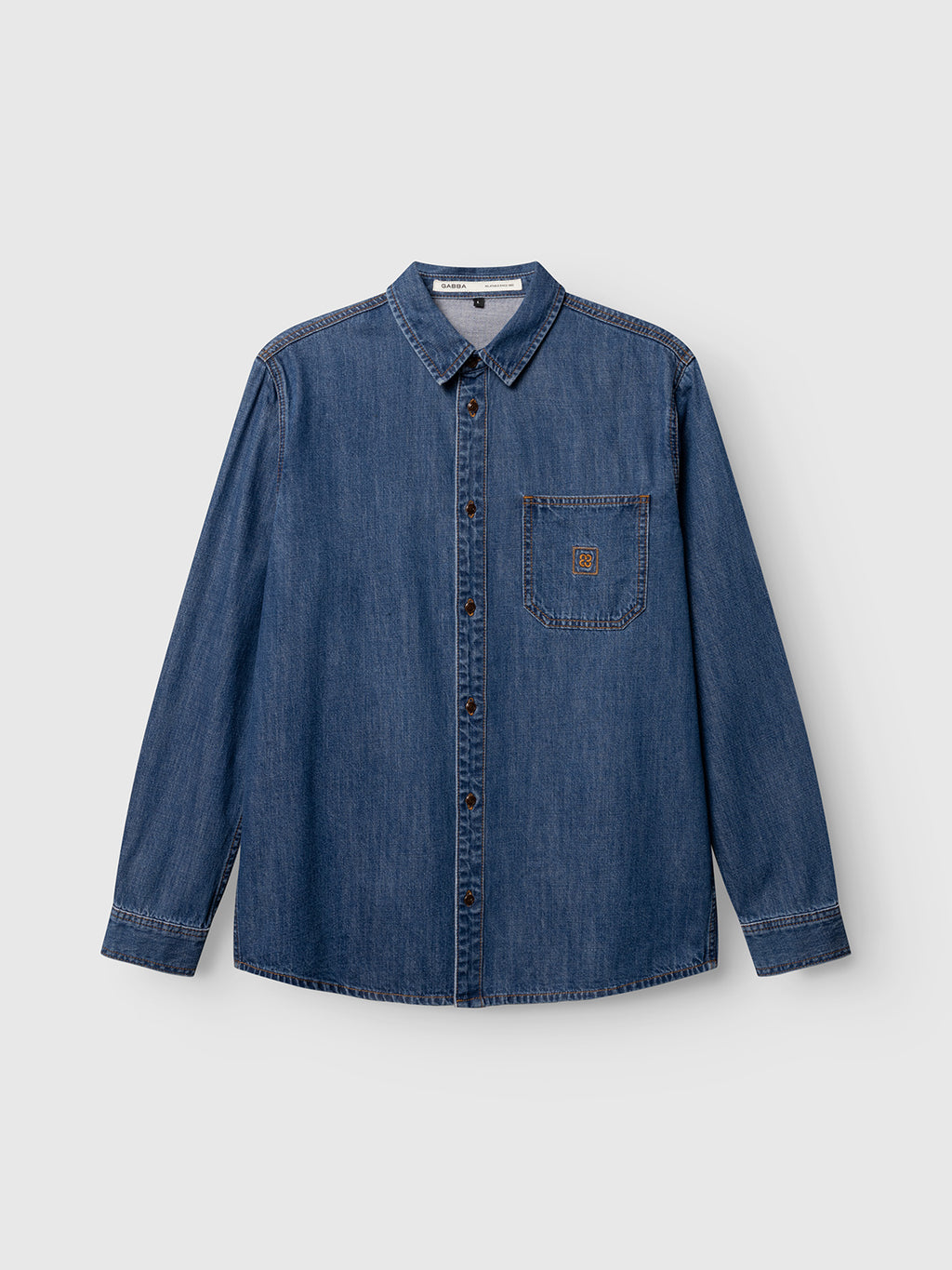 The Gabba GABsven Reg Wish LS Shirt in Mid Blue Denim features long sleeves, a collar, front buttons, and a single chest pocket. This regular fit cotton shirt is laid flat on a plain light gray background, making it a versatile wardrobe essential from Gabba for any occasion.