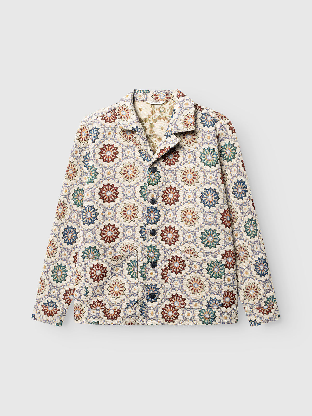 Introducing the GABsimone Nava LS - Birch by Gabba: a relaxed-fit long-sleeve button-up jacket crafted from jacquard fabric, featuring a vibrant floral geometric pattern in red, green, blue, and beige tones on a light background. This jacket seamlessly blends comfort with contemporary style.