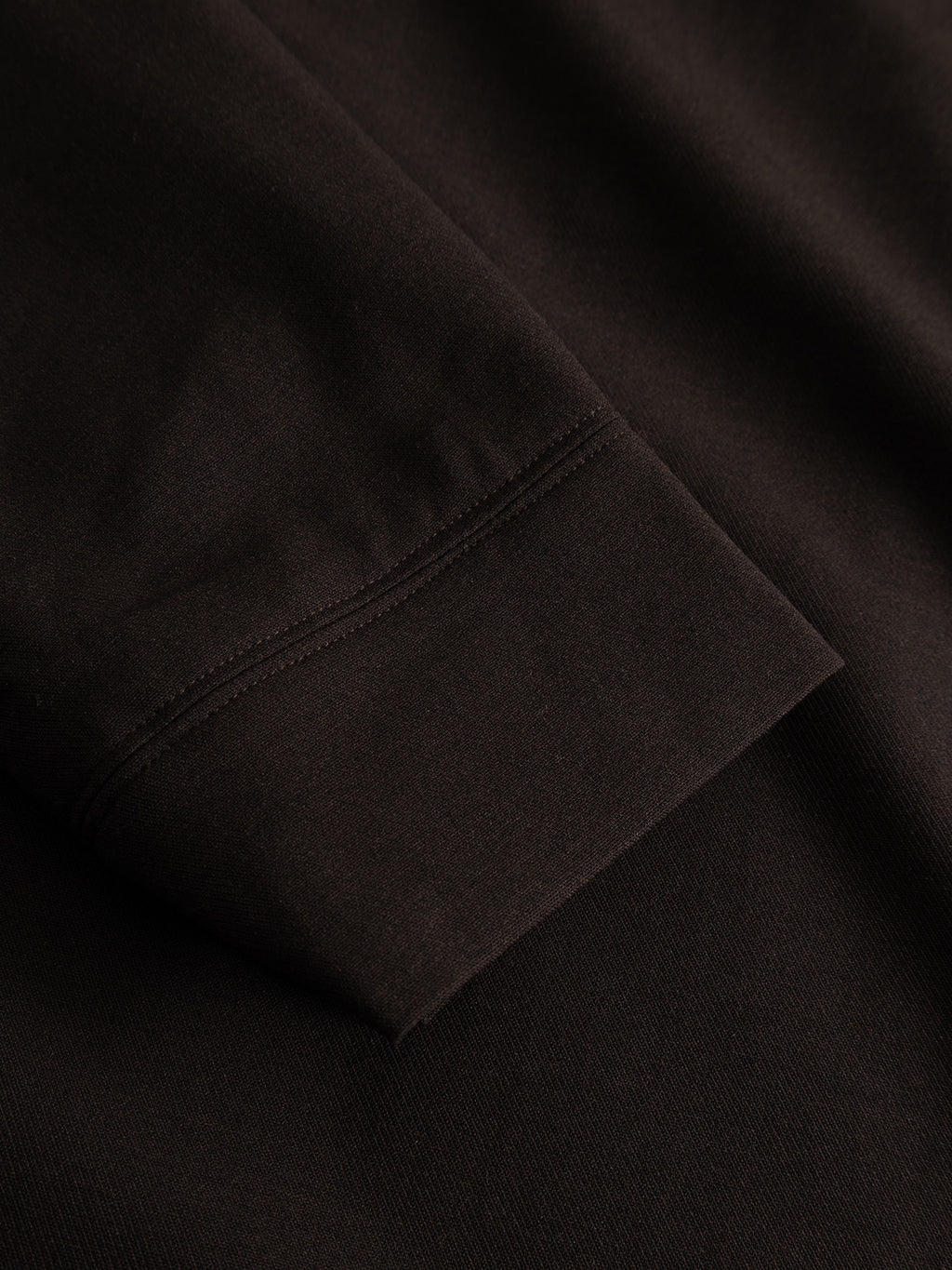 Close-up of the GABnik Phin GRS - Brown Slate by Gabba, a brown long-sleeve garment made from a premium wool and viscose blend, highlighting the detailed cuff stitching and smooth fabric texture.