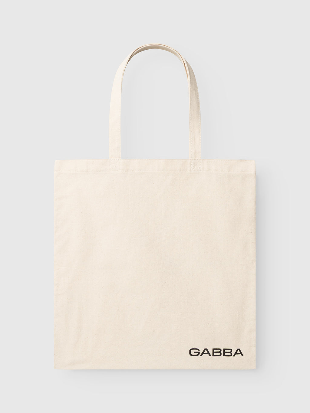 Off-white GABworn Tote Bag with two shoulder straps and Gabba branding printed in the bottom right corner.