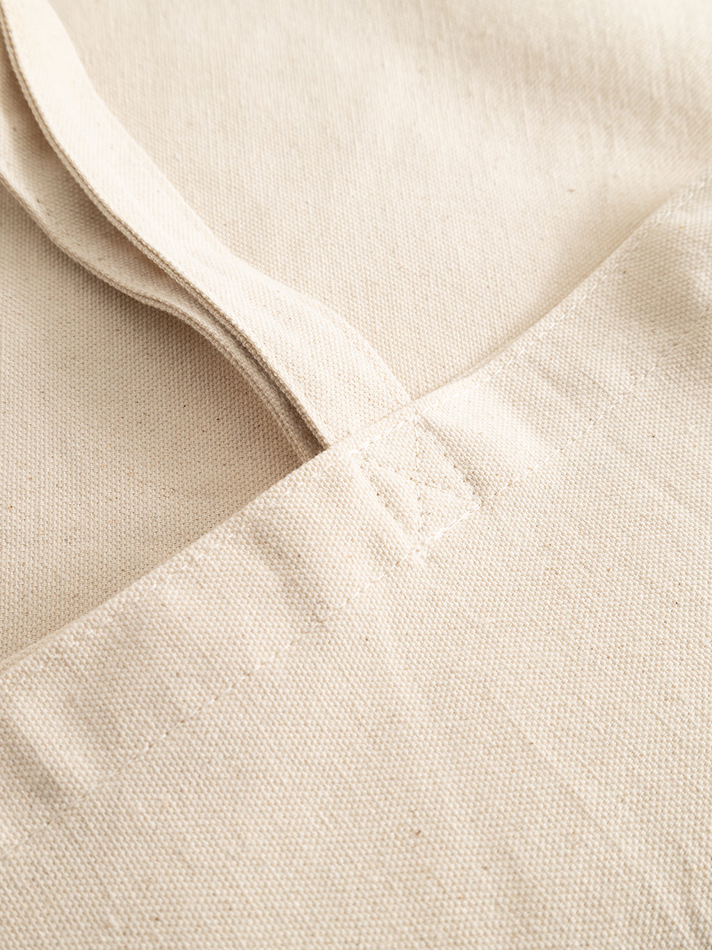 Close-up of an off-white GABworn Tote Bag showing the stitched Gabba branding on the handle attachment.