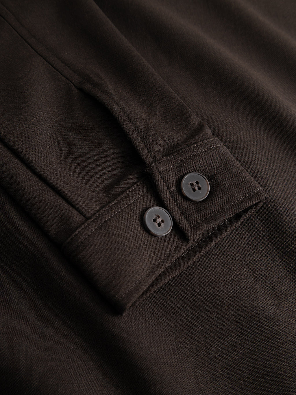 Close-up of the Gabba GABtogger Push Phin LS Overshirt GRS in Brown Slate, showcasing its regular fit sleeve crafted from a smooth wool-viscose blend, detailed with two black buttons on the cuff and simple stitching.