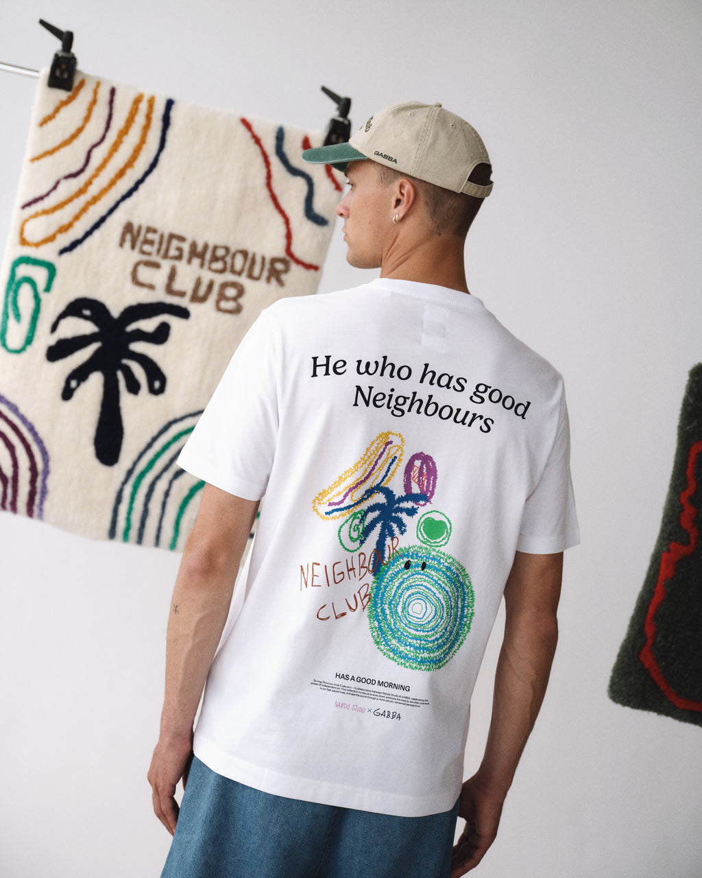 A man in a Gabba GABnigel Nando SS T-shirt GOTS - White, featuring colorful abstract designs and 