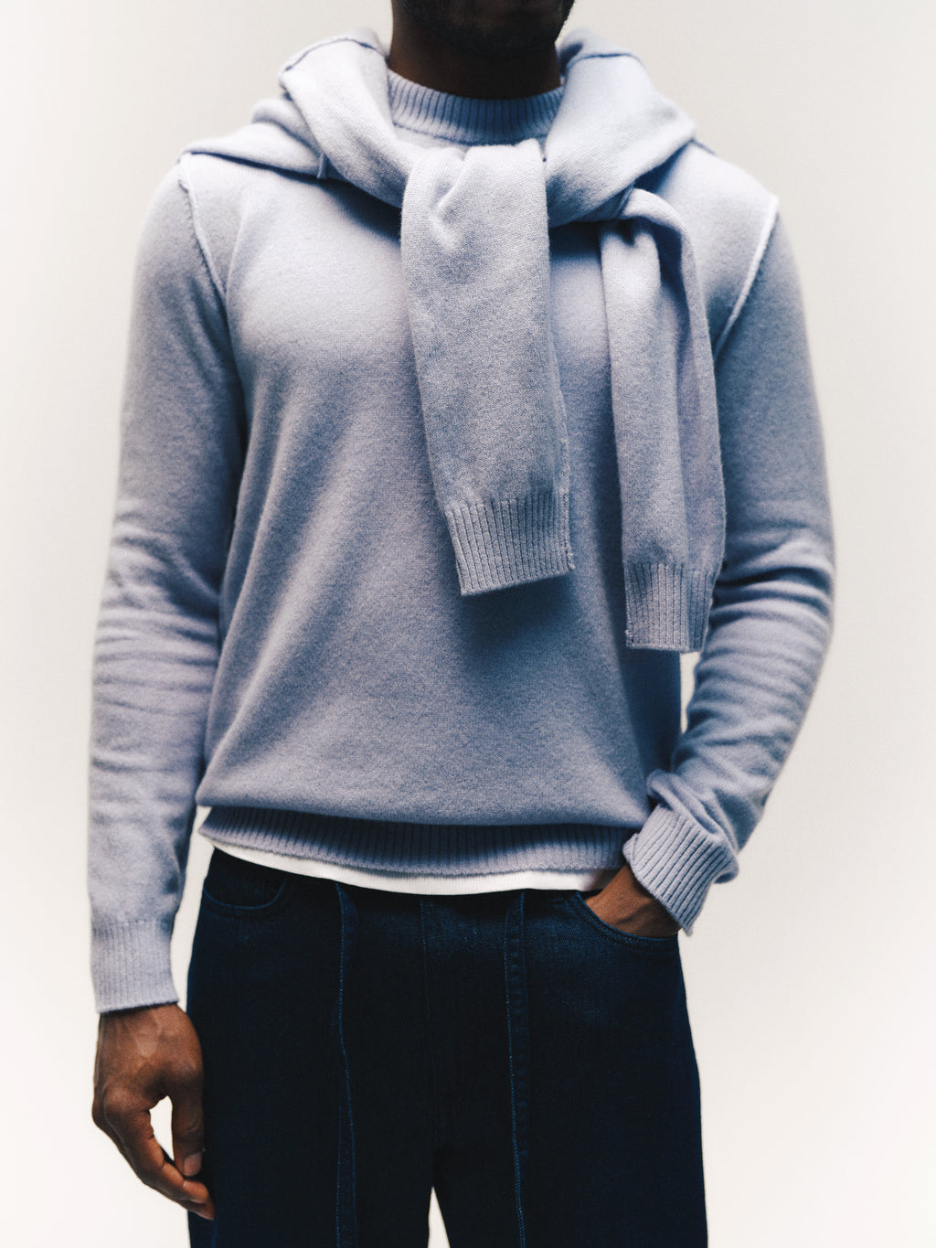 A person wearing the Gabba GABtokota Element Aico LS Knit sweater in Dusty Blue, with a matching soft wool layer draped over their shoulders and paired with dark jeans, standing against a neutral background for an effortlessly comfortable everyday look.