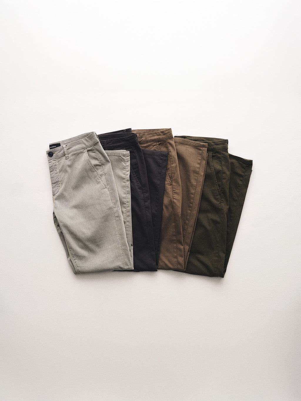 Five pairs of Gabba GABpaul K3280 Dale Chino pants in blue are neatly folded with French pockets and arranged side by side on a light background.